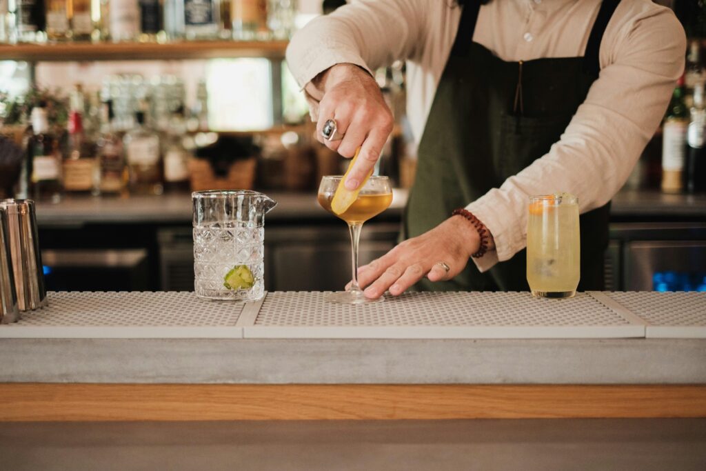 Bartender putting lemon garnish on speciality cocktail